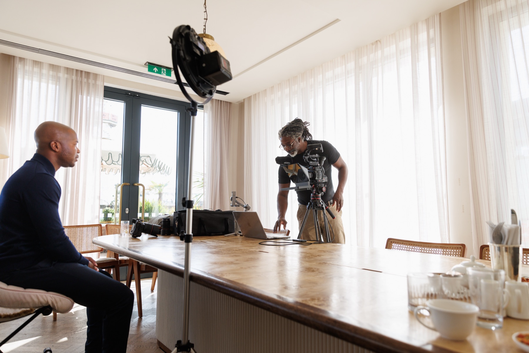 Bright home interior converted into an interview set, subject seated at a large table