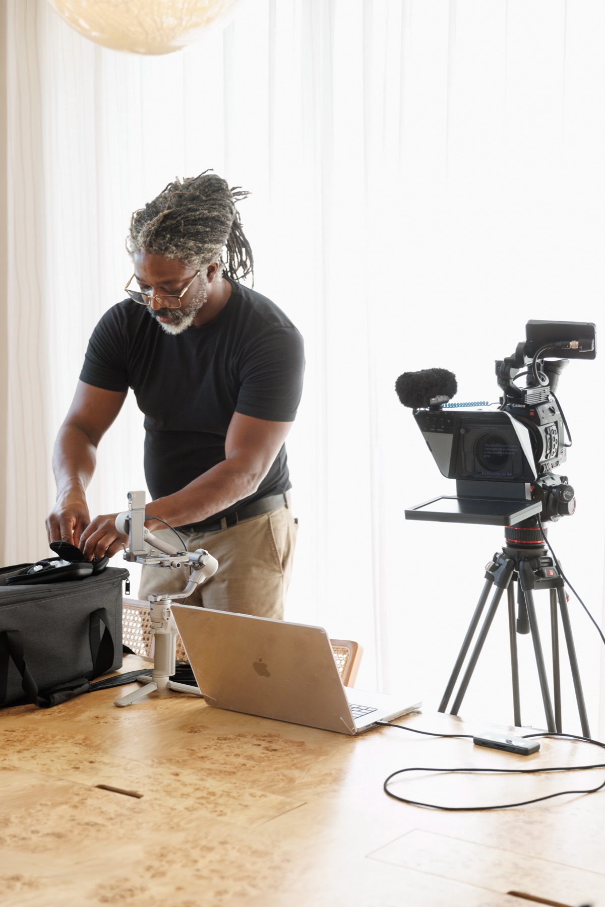 Kevan preparing camera equipment beside a teleprompter rig
