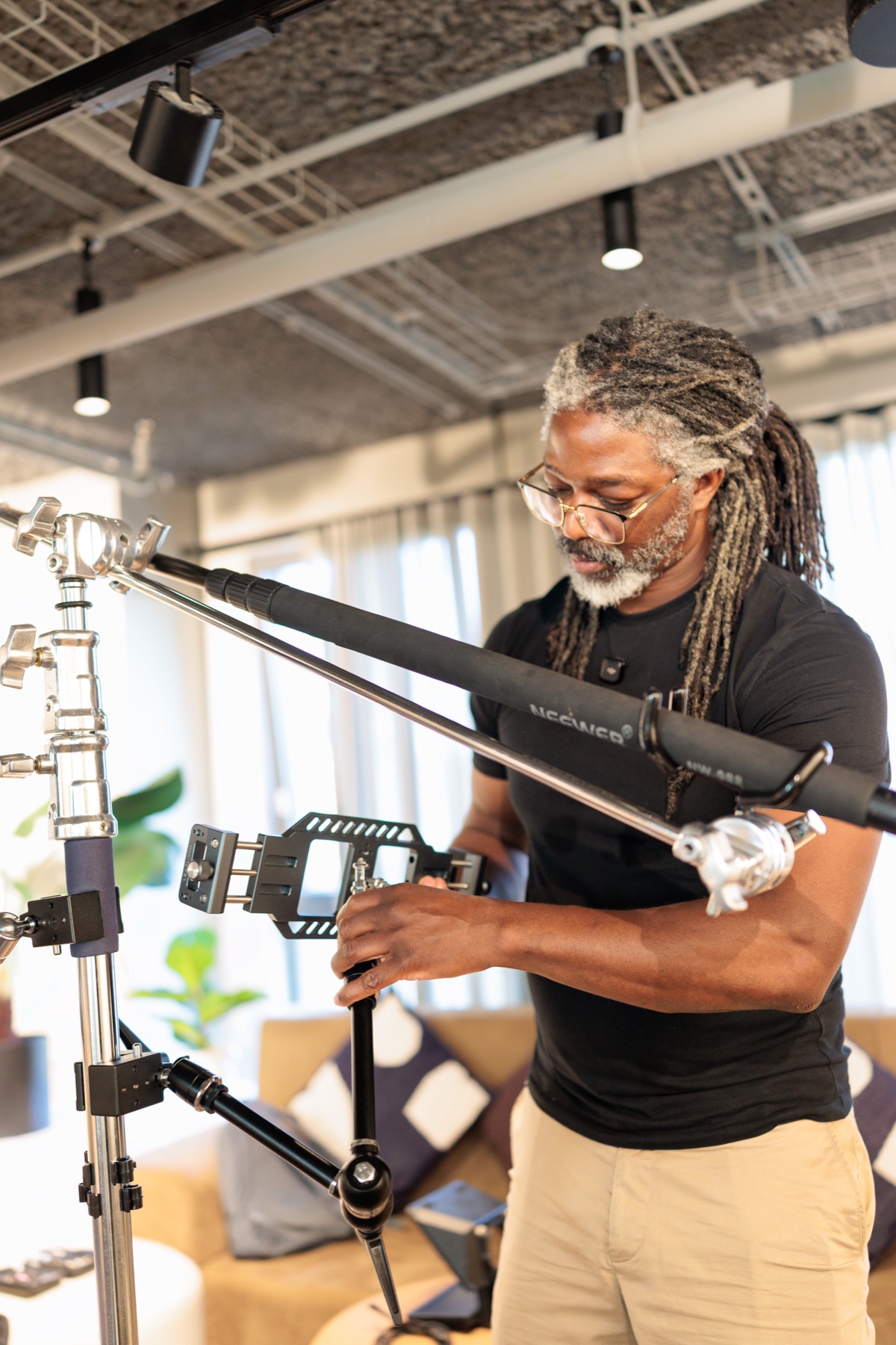 Kevan rigging a boom arm on a C-stand in a client's office
